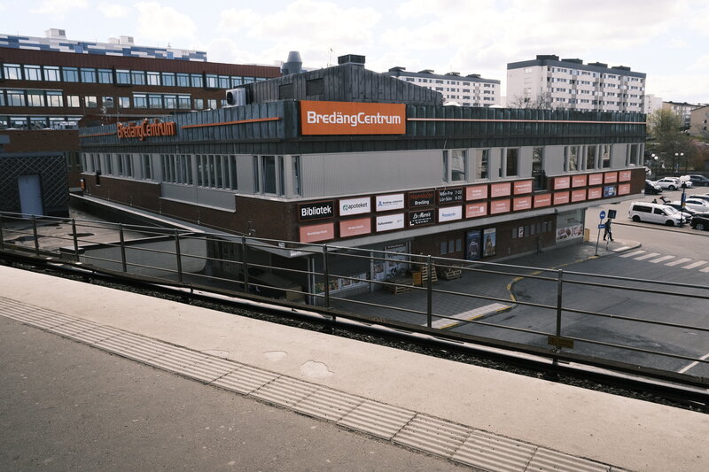 Bredäng Centrum shopping centre seen from the metro platform, brick facade with large orange signage